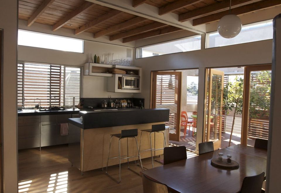 Timber beams above a kitchen island and an open dining space